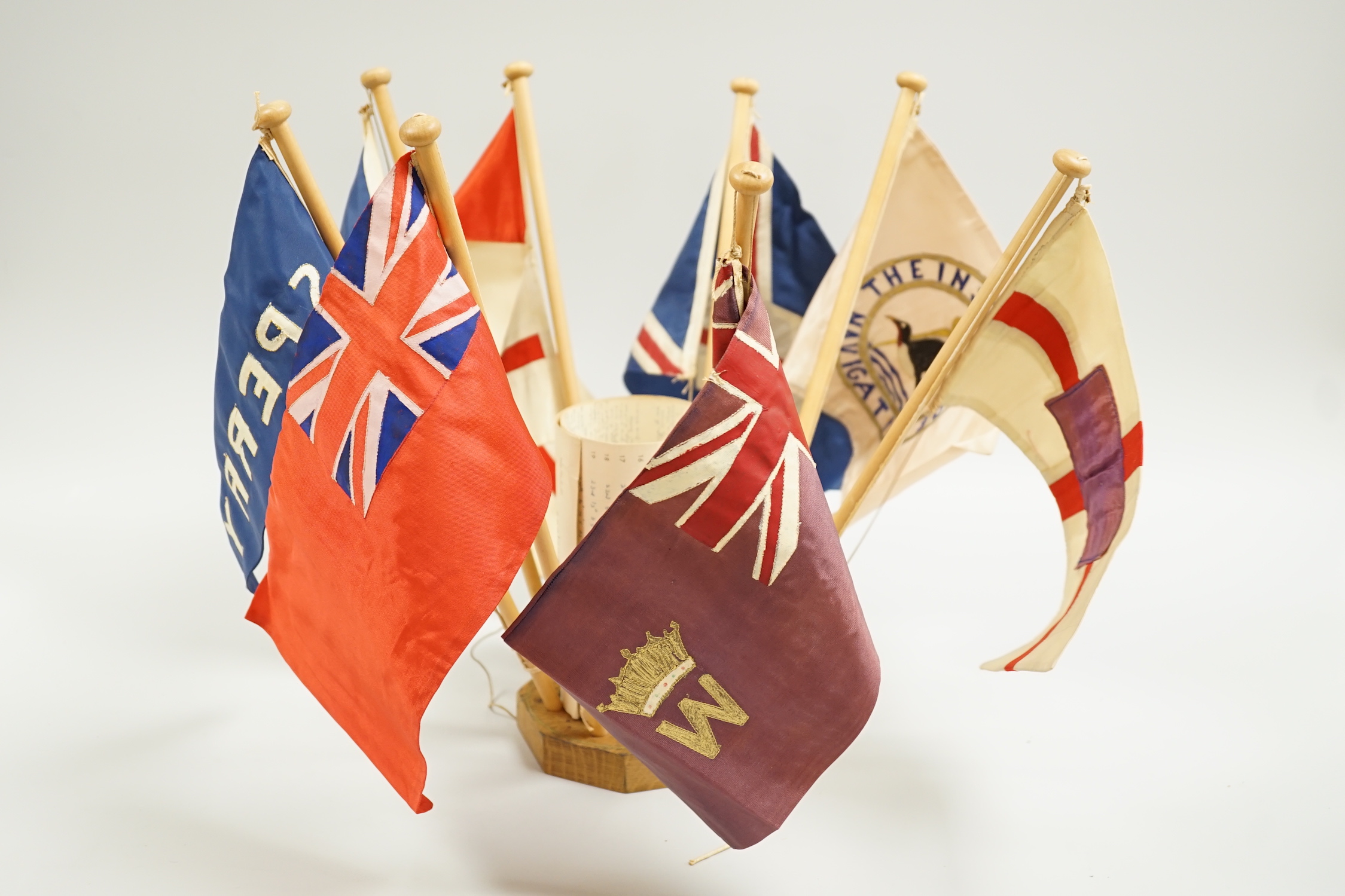 A collection of shipping flags on a stand and a boxed silver oar, engraved: 2nd, Destroyer Flotilla Regatta 1934, 29.5cm long